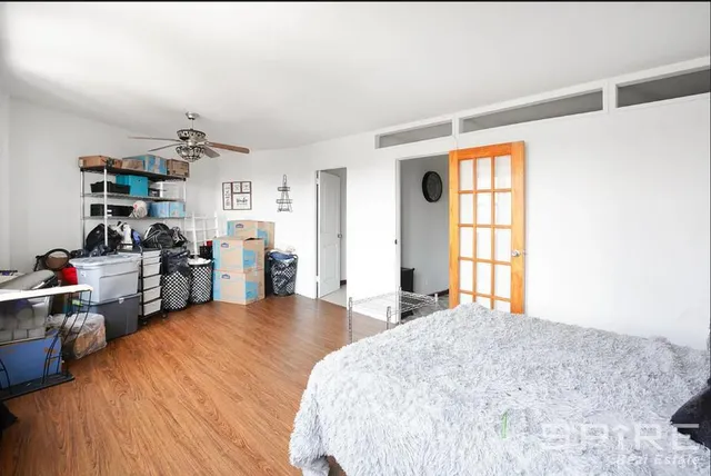 a bedroom with a bed and large wooden floor