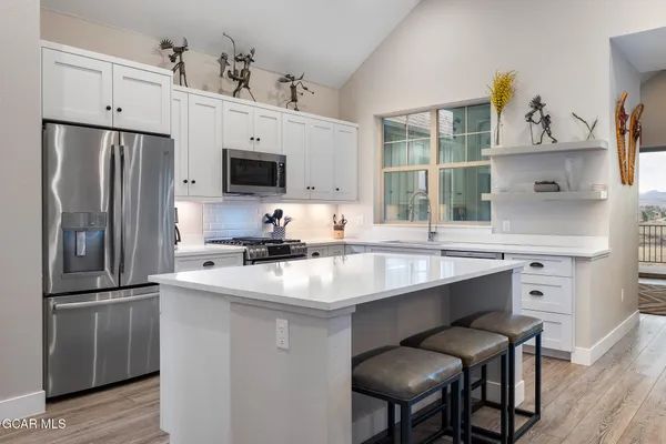 a kitchen with stainless steel appliances a sink and a refrigerator