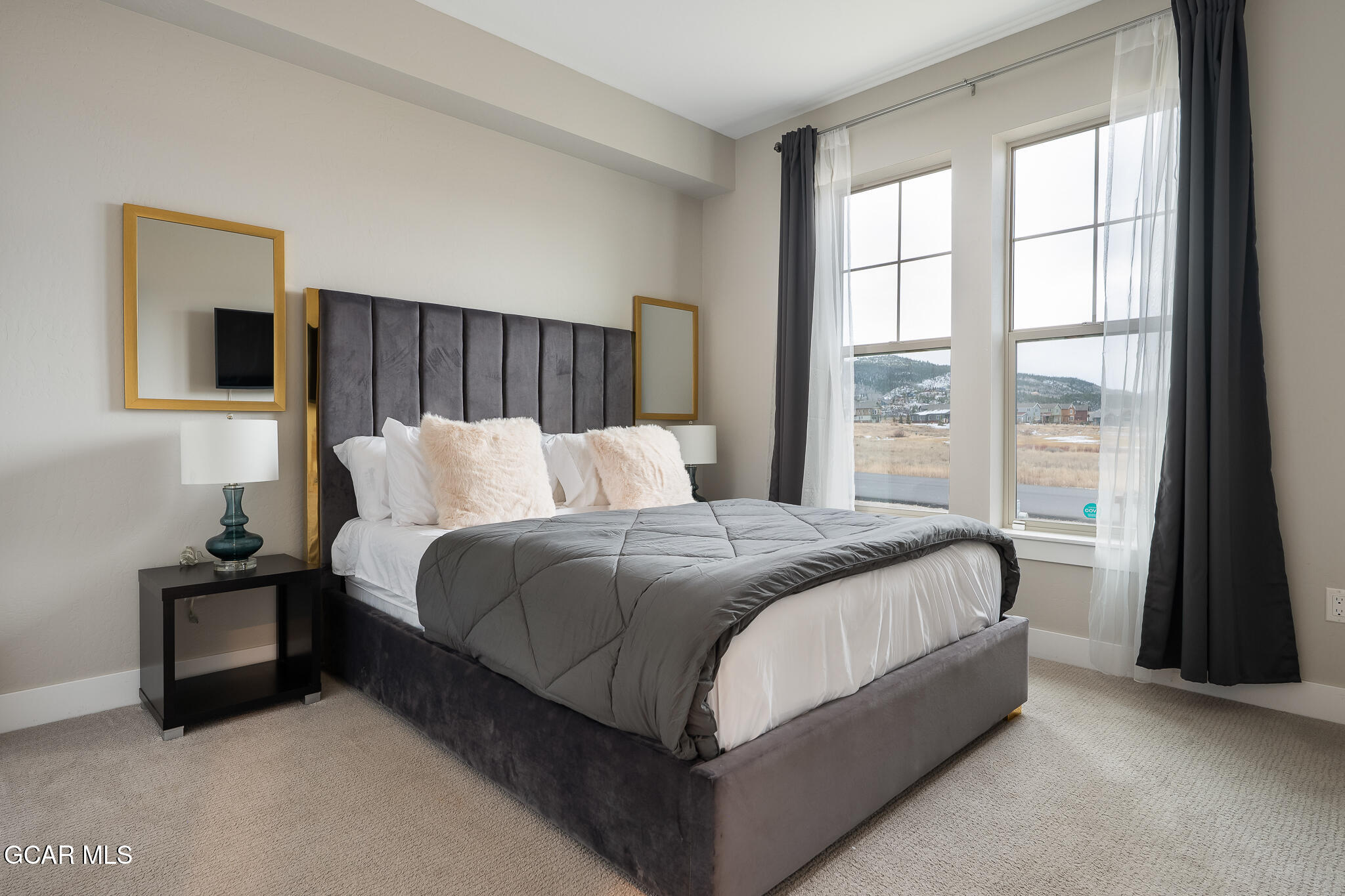 74 Eagle Ridge Drive Granby, CO 80446 - Photo 29 of 44 a bedroom with a bed lamp and a large window