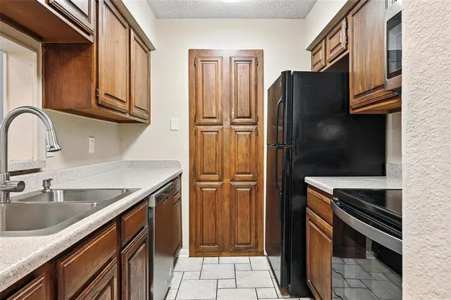 a kitchen with stainless steel appliances granite countertop a refrigerator and a sink