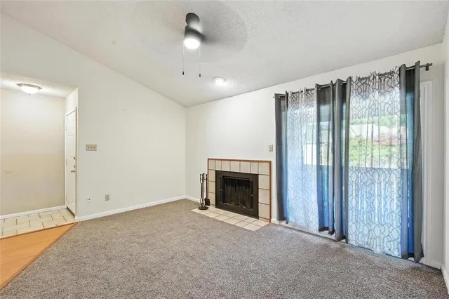 an empty room with fireplace cabinet and windows