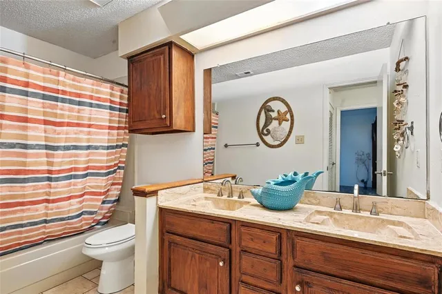 a bathroom with a granite countertop sink mirror and toilet