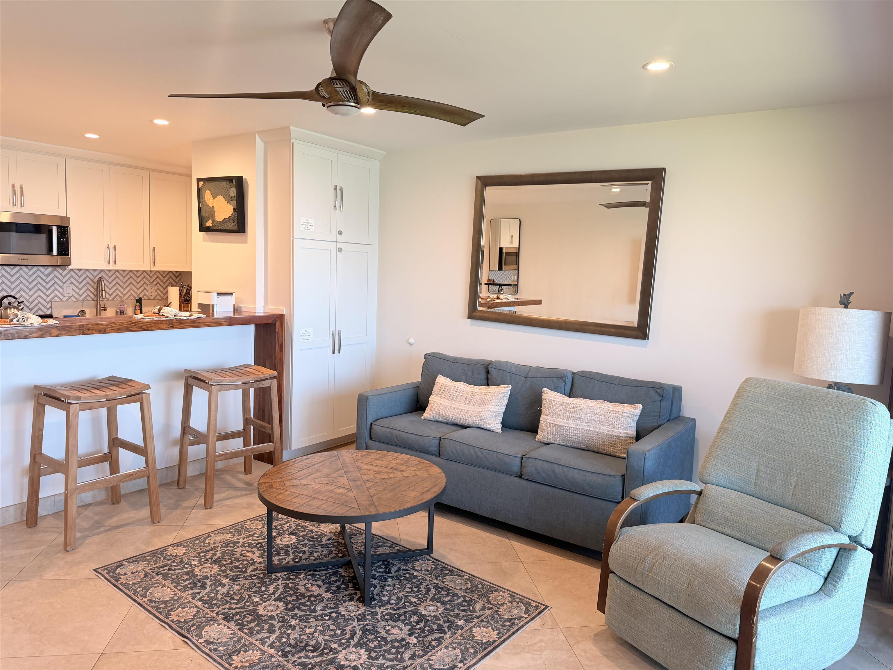 3701 Lower Honoapiilani Road, Unit 103 Lahaina, HI 96761 - Photo 12 of 38 a living room with furniture a rug and a table