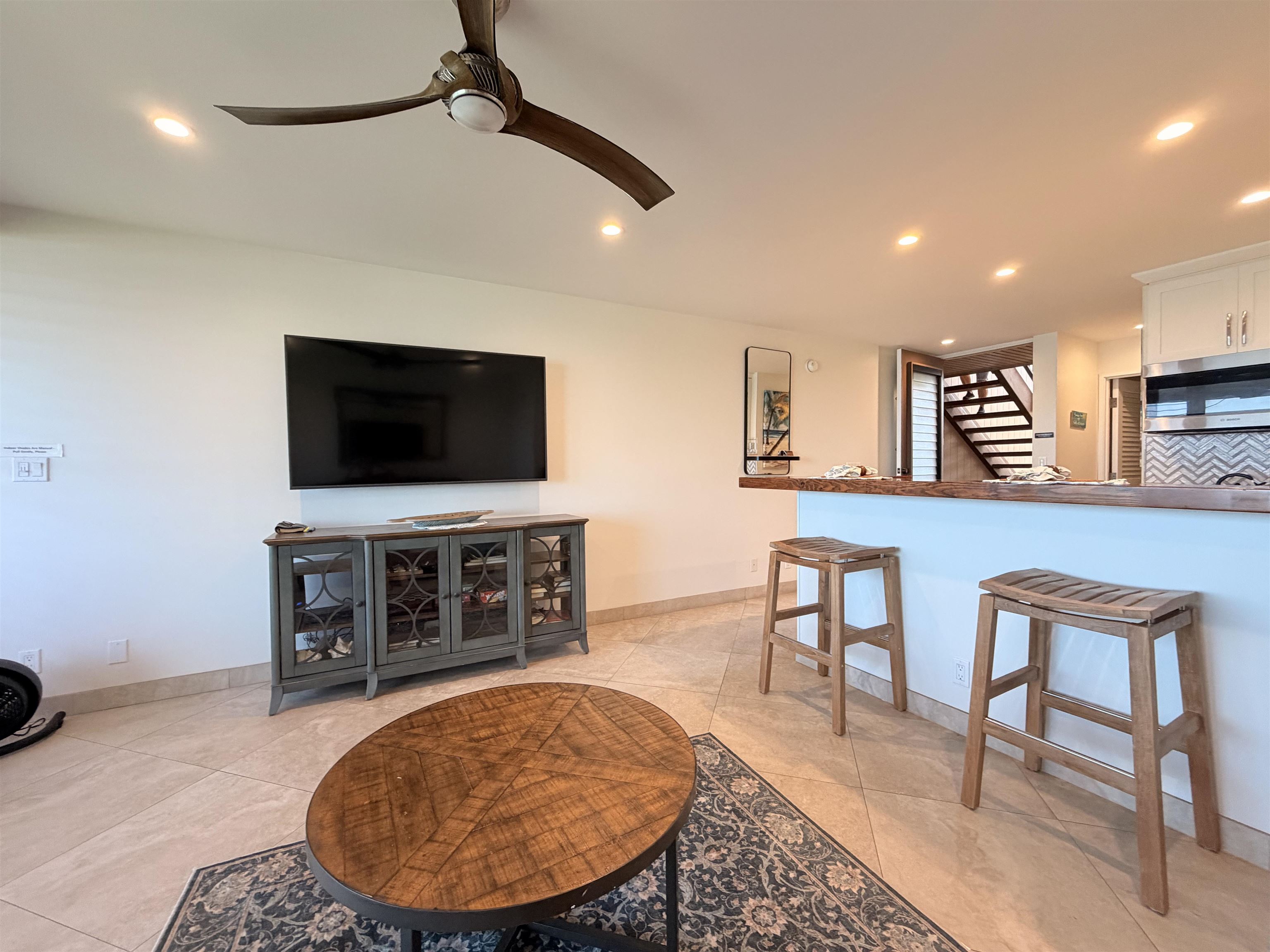 3701 Lower Honoapiilani Road, Unit 103 Lahaina, HI 96761 - Photo 16 of 38 a living room with furniture and a flat screen tv