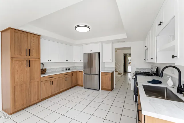 a kitchen with a refrigerator sink and wooden cabinets
