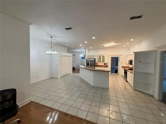 a kitchen with stainless steel appliances kitchen island granite countertop a refrigerator and a stove top oven