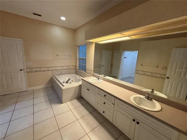 a bathroom with a granite countertop sink mirror and bathtub