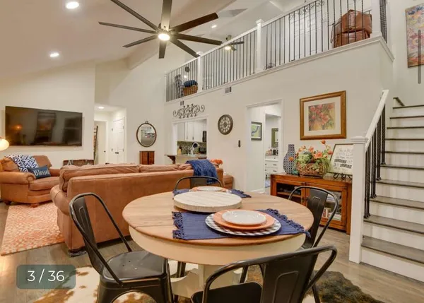 a living room with furniture and a large mirror on a dresser
