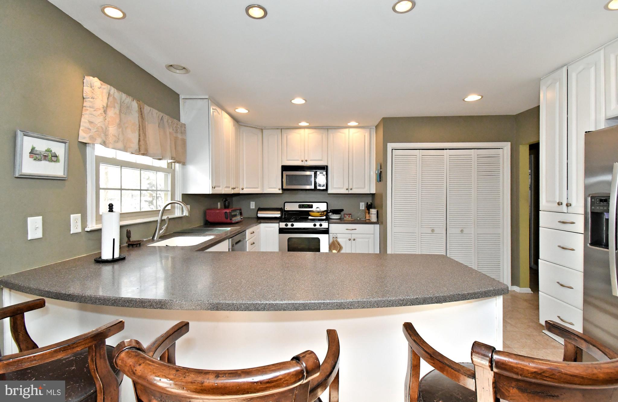 1113 Clark Road Wyndmoor, PA 19038 - Photo 23 of 68 a kitchen with stainless steel appliances granite countertop a refrigerator a stove a sink a dining table and chairs