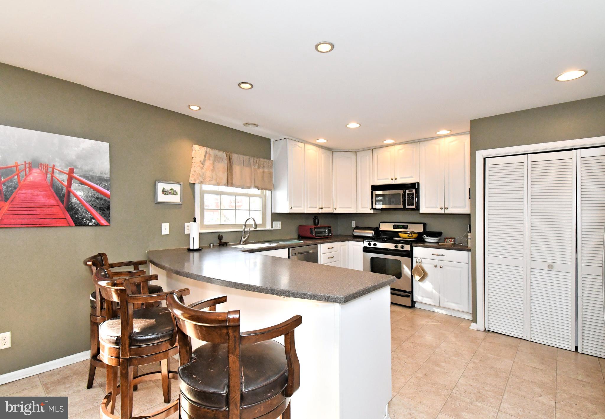 1113 Clark Road Wyndmoor, PA 19038 - Photo 24 of 68 a kitchen with stainless steel appliances granite countertop a stove top oven a sink a refrigerator and white cabinets
