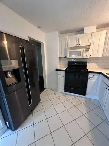 a kitchen with stainless steel appliances kitchen island granite countertop a refrigerator a sink a stove and island