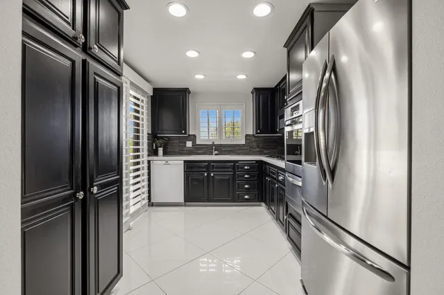 a kitchen with stainless steel appliances granite countertop a refrigerator and a sink