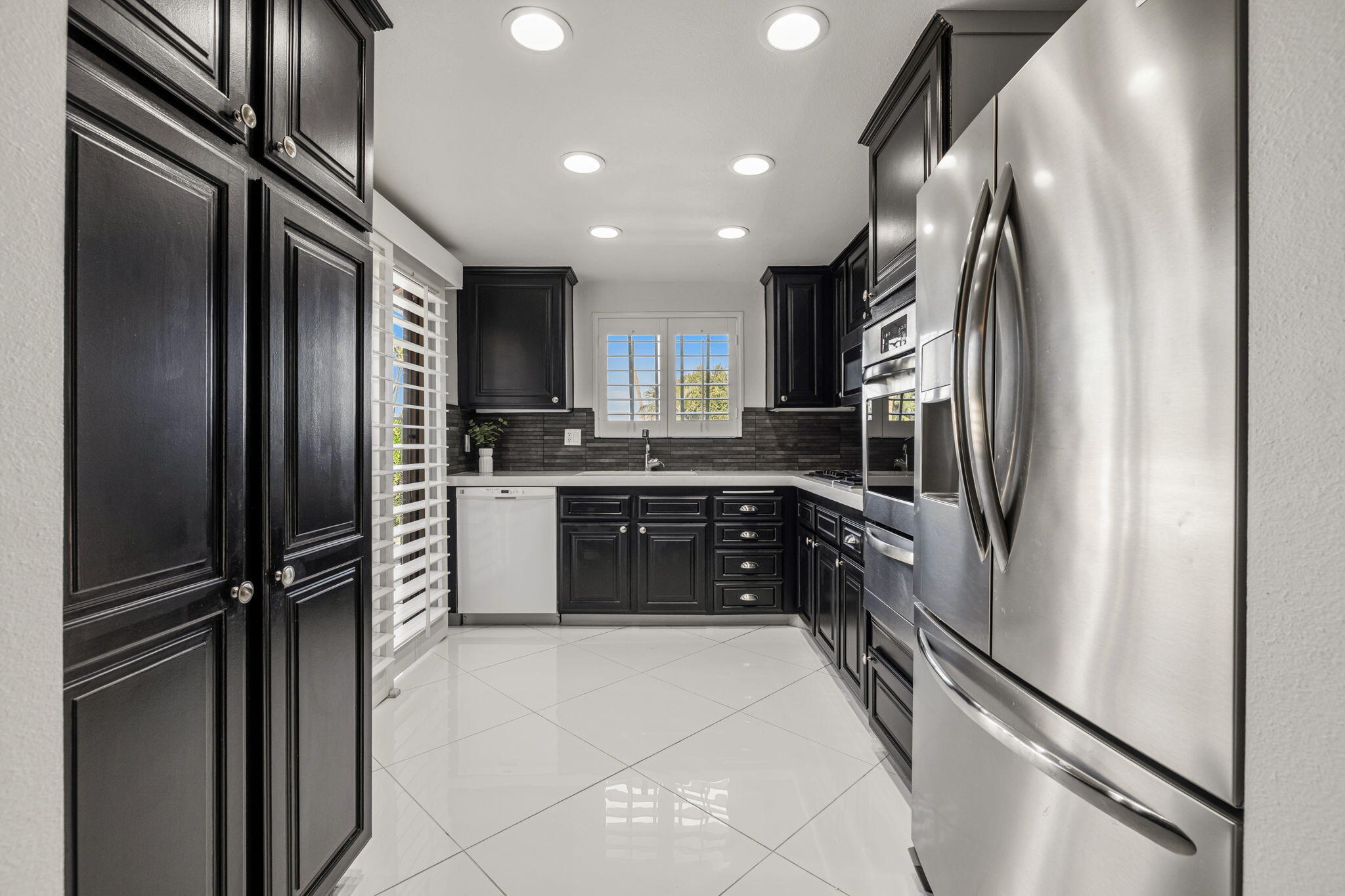 a kitchen with stainless steel appliances granite countertop a refrigerator and a sink