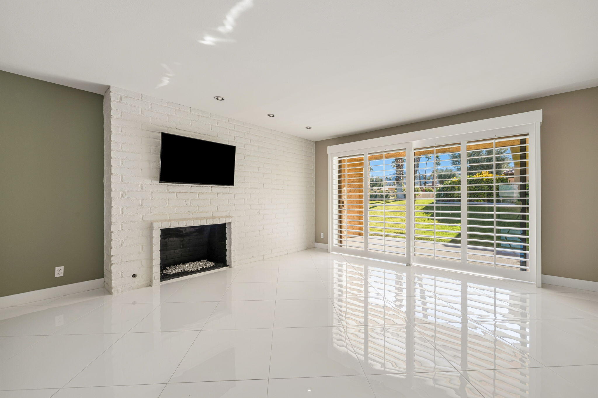72915 Homestead Road Palm Desert, CA 92260 - Photo 11 of 45 a view of an empty room with a fireplace and a window