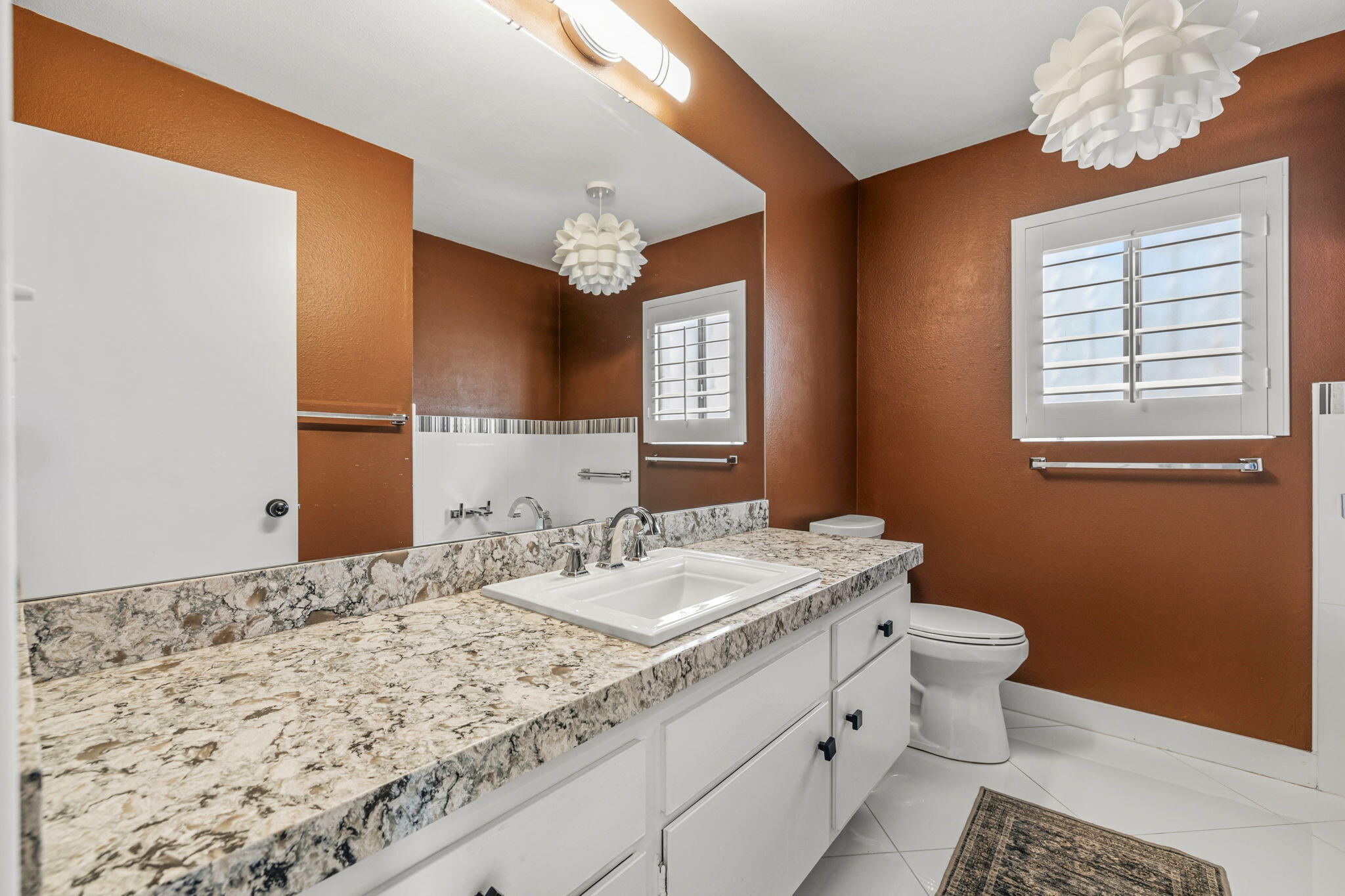 72915 Homestead Road Palm Desert, CA 92260 - Photo 18 of 45 a bathroom with a granite countertop sink a toilet and a mirror