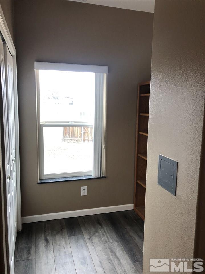 170 Redstone Drive Reno, NV 89512 - Photo 10 of 17 an empty room with wooden floor and windows