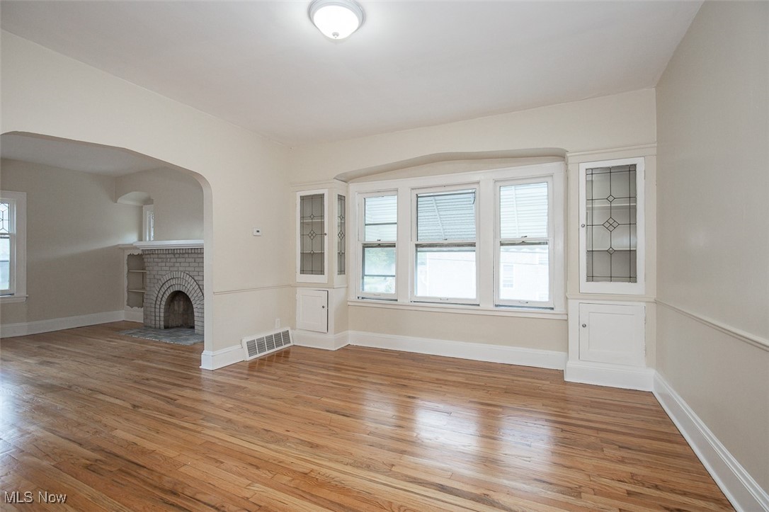 3616 Hildana Road Cleveland, OH 44120 - Photo 15 of 27 Unfurnished living room with a fireplace, light wood-style flooring, and arched walkways