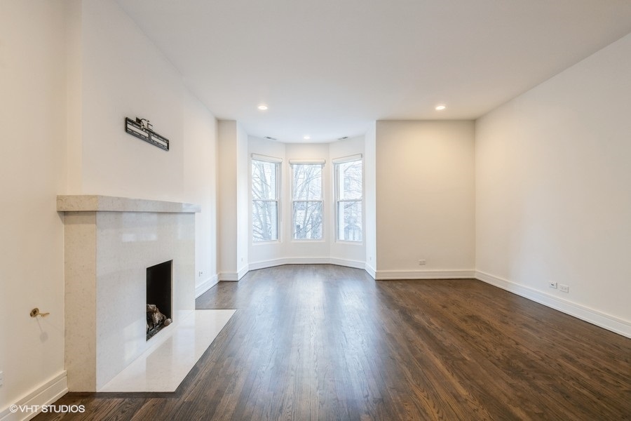 1439 North Dearborn Street, Unit 2 Chicago, IL 60610 - Photo 2 of 18 a view of a livingroom with wooden floor and a fireplace