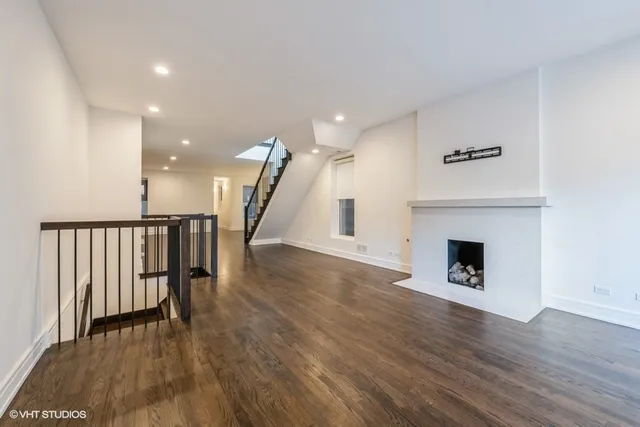a view of a hallway with wooden floor and a fireplace