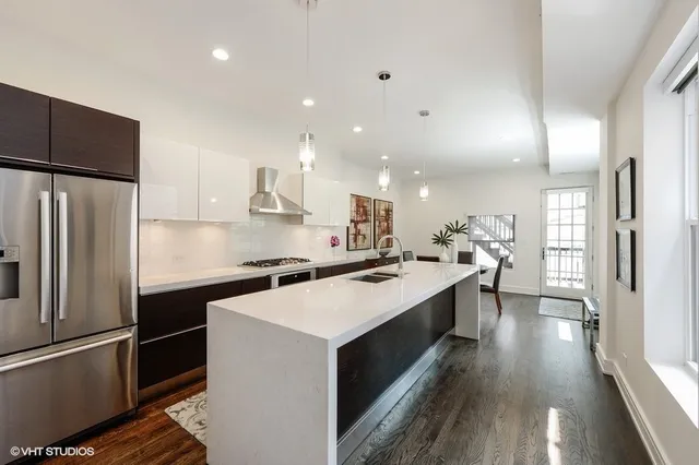 a kitchen with stainless steel appliances a sink stove refrigerator and cabinets