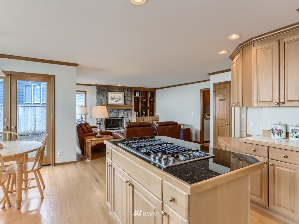 3007 215th Street Southeast Bothell, WA 98021 - Photo 13 of 28 a kitchen with a stove a sink dishwasher and white cabinets with wooden floor