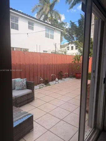 a view of backyard with potted plants and a large tree