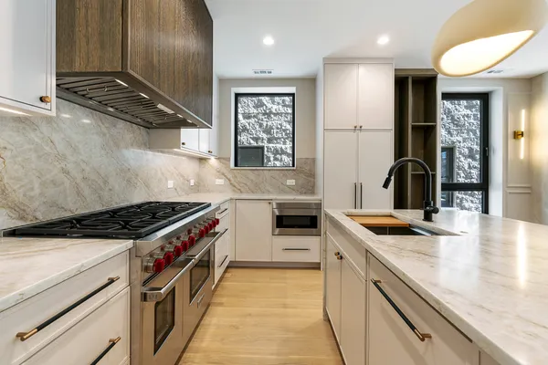 a kitchen with kitchen island granite countertop a stove and a sink