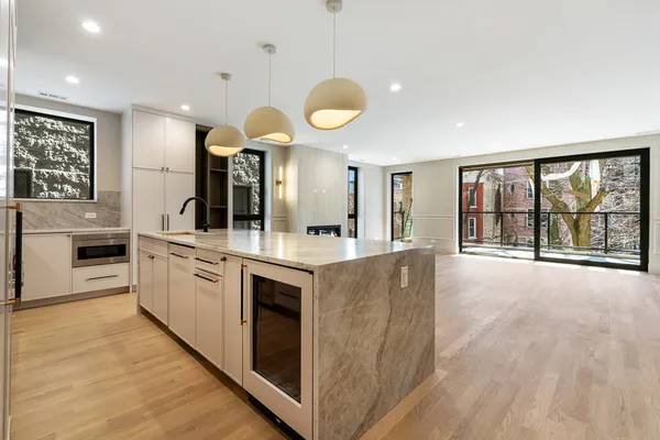 a large kitchen with kitchen island a large counter top space a sink stainless steel appliances and cabinets