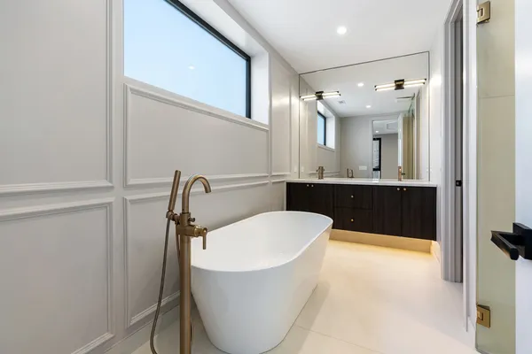 a bathroom with a tub sink and mirror
