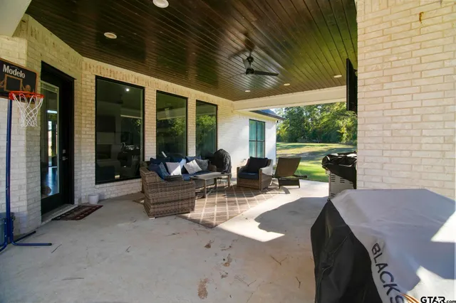 a view of a patio with table and chairs potted plants with floor to ceiling window