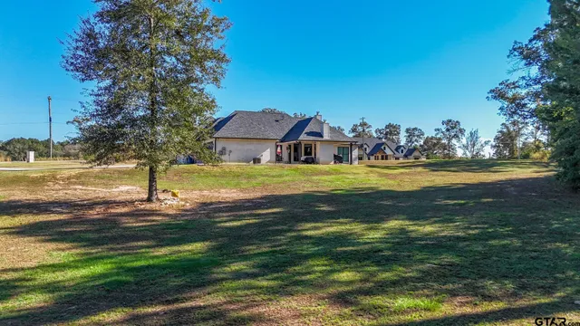 a view of swimming pool with lawn chairs and plants