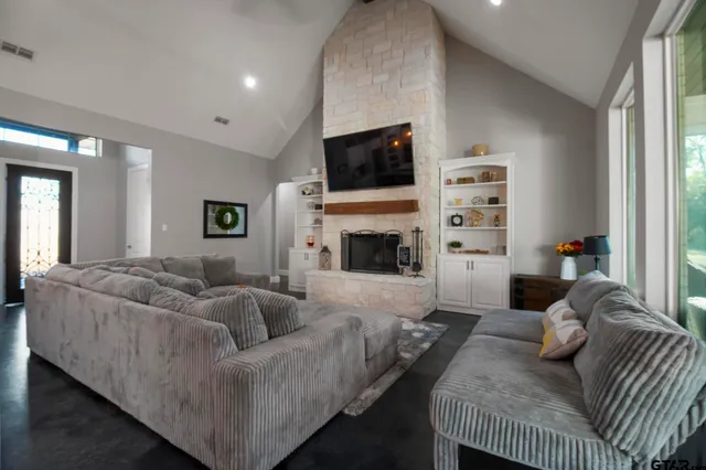 a living room with furniture a flat screen tv and a fireplace