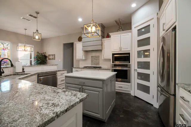 a kitchen with stainless steel appliances granite countertop a stove and a refrigerator