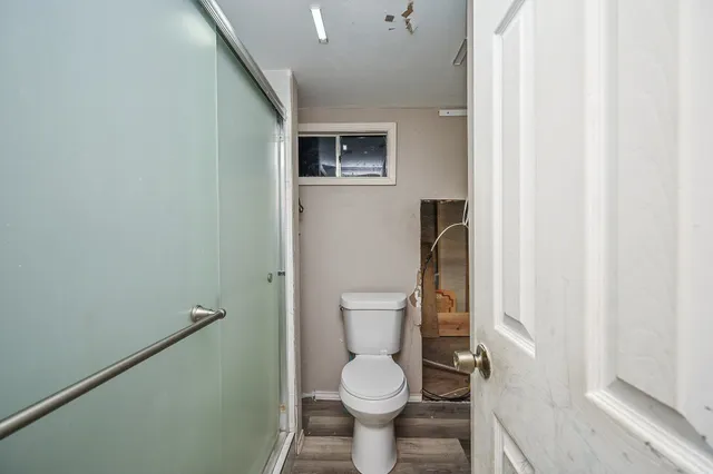 a bathroom with a toilet and a shower