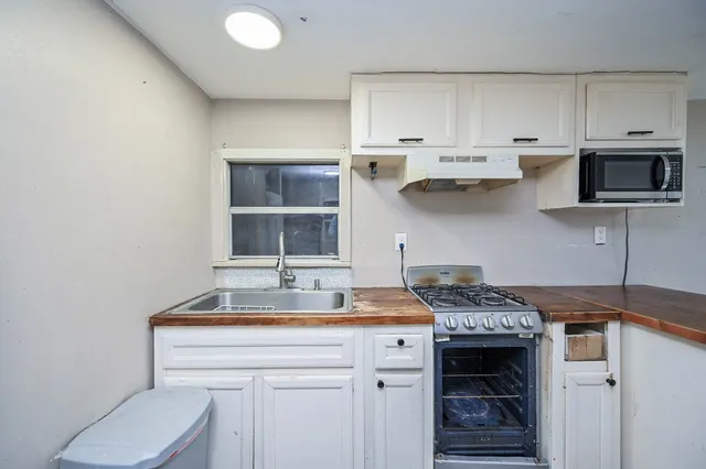 a kitchen with stainless steel appliances a stove and a microwave