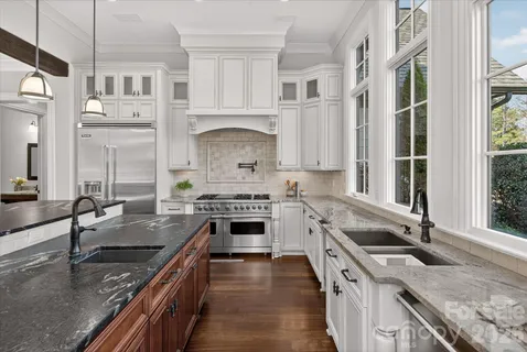 a kitchen with granite countertop cabinets stainless steel appliances and wooden floor