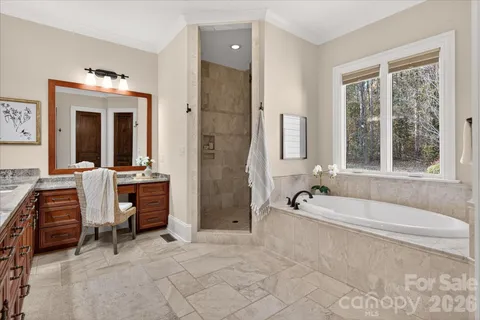 a spacious bathroom with a granite countertop sink mirror and a bath tub