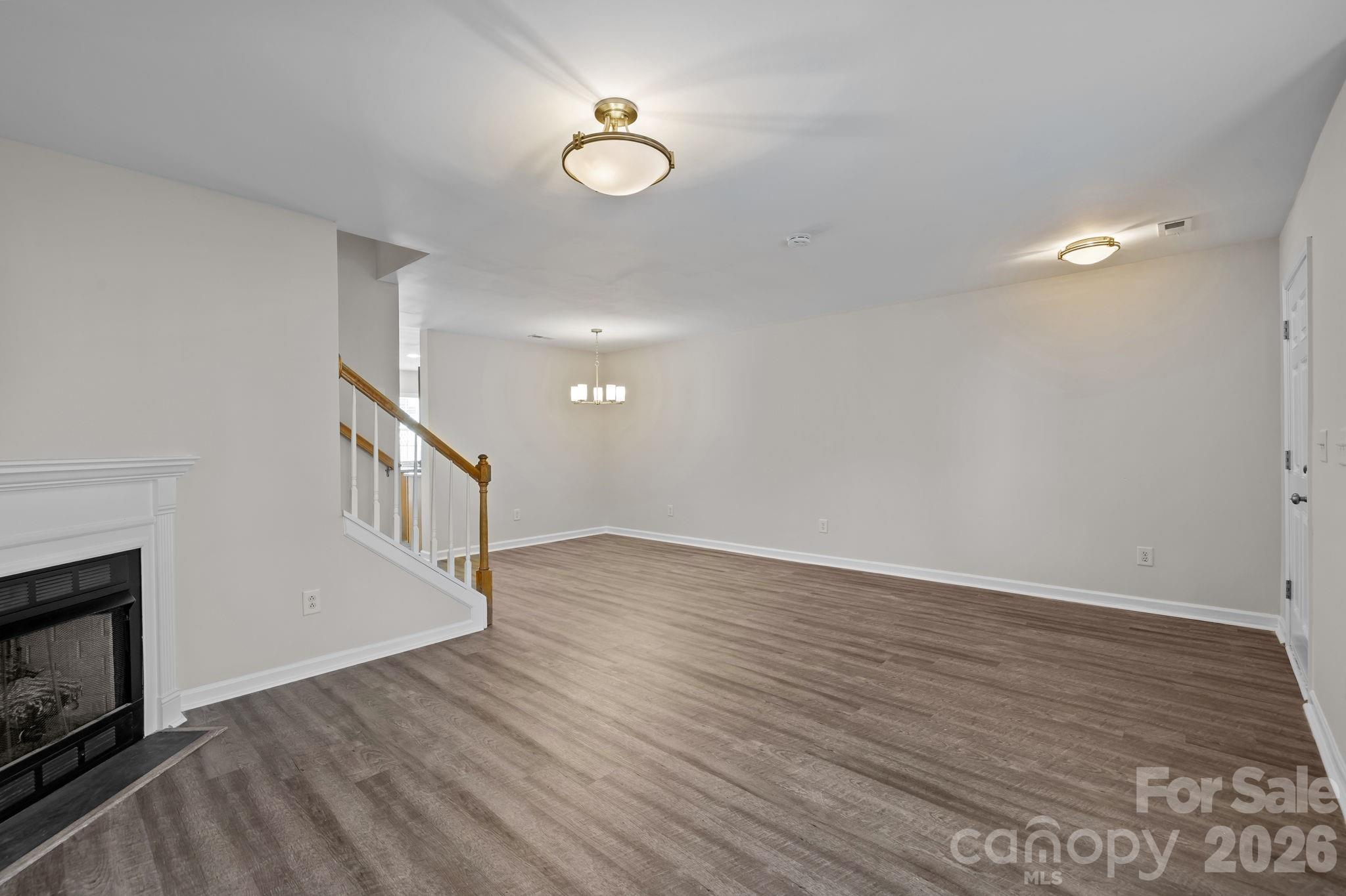 209 Primrose Walk Fort Mill, SC 29715 - Photo 11 of 39 a view of an empty room with wooden floor and a fireplace