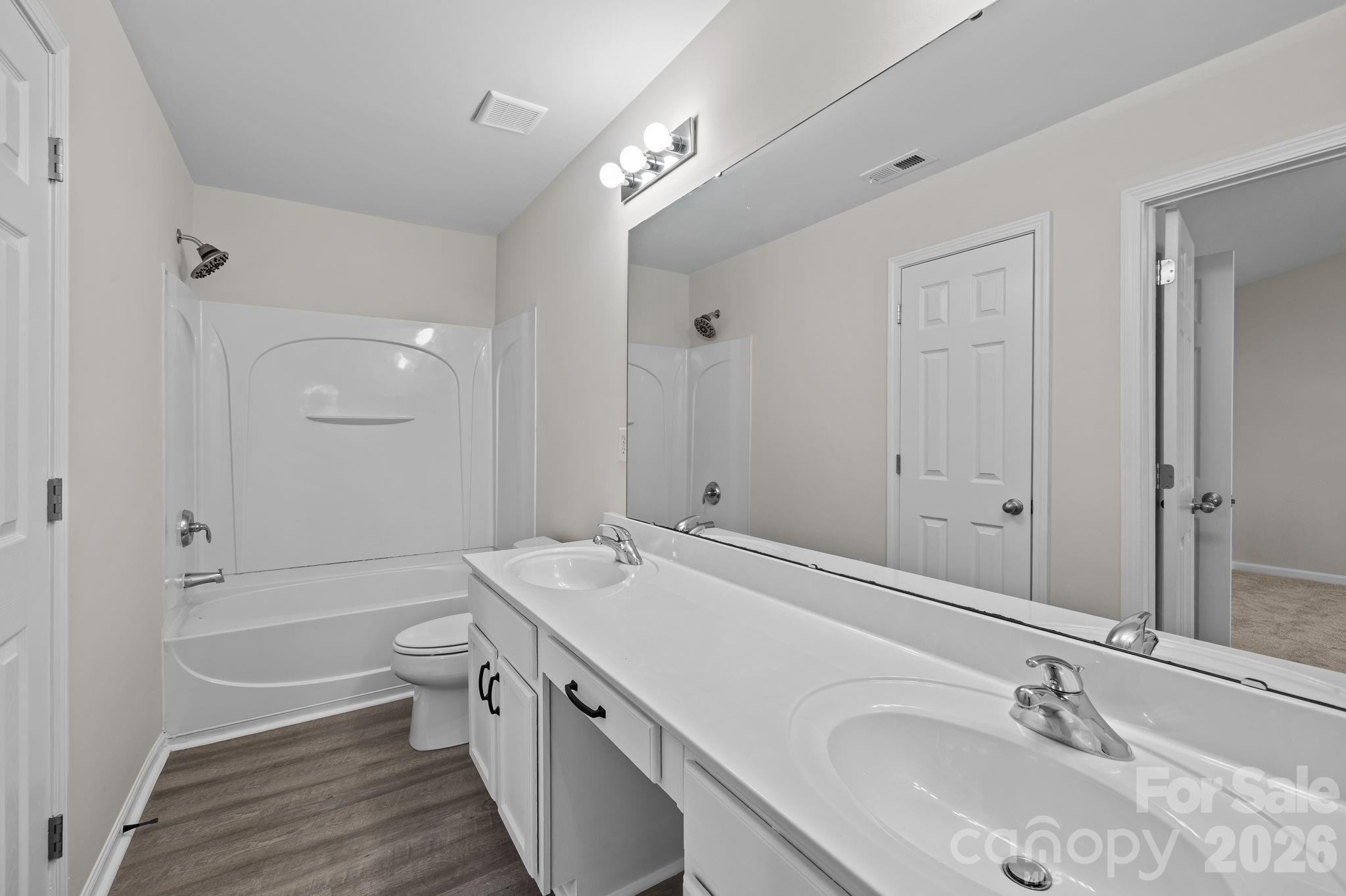 209 Primrose Walk Fort Mill, SC 29715 - Photo 22 of 39 a bathroom with a granite countertop sink a toilet and shower
