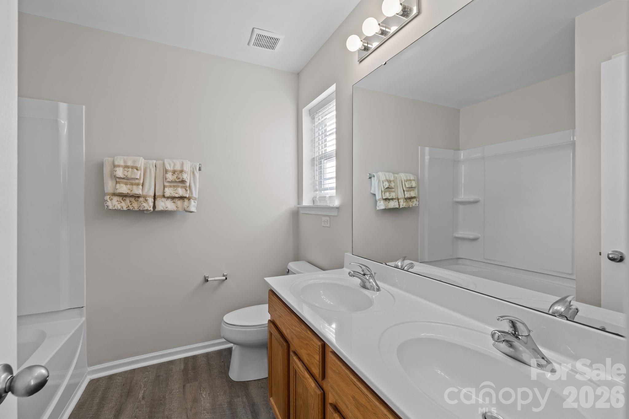 209 Primrose Walk Fort Mill, SC 29715 - Photo 27 of 39 a bathroom with a granite countertop sink a toilet and a mirror