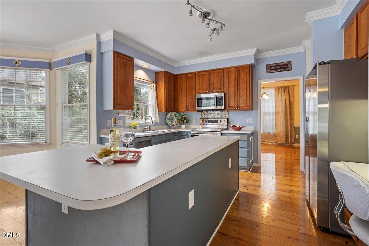 2804 Shofield Court Raleigh, NC 27615 - Photo 7 of 37 a kitchen with stainless steel appliances granite countertop a sink a stove and a refrigerator