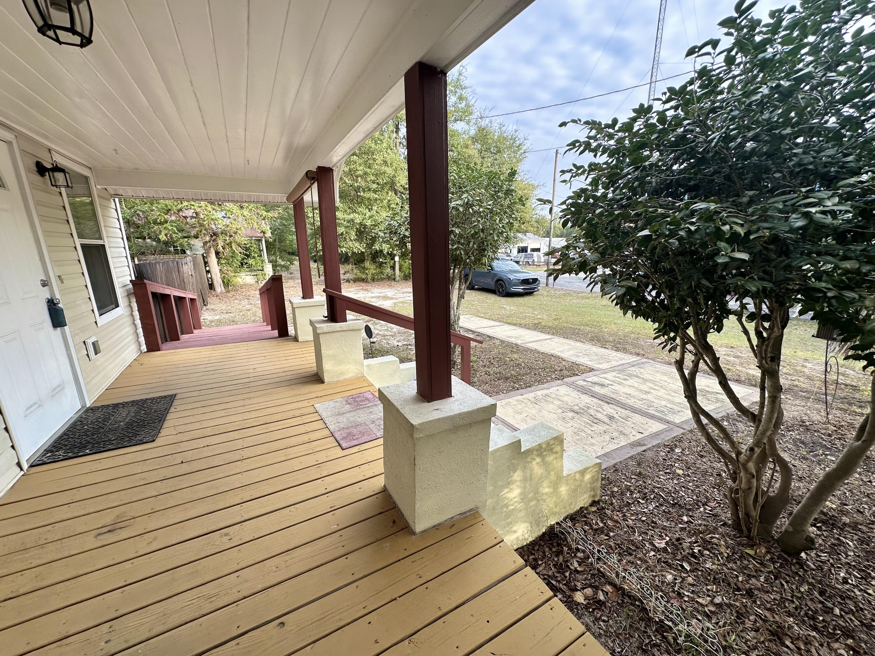 120 North Davis Lane DeFuniak Springs, FL 32433 - Photo 12 of 58 a view of a patio with lawn chairs floor to ceiling window with wooden floor