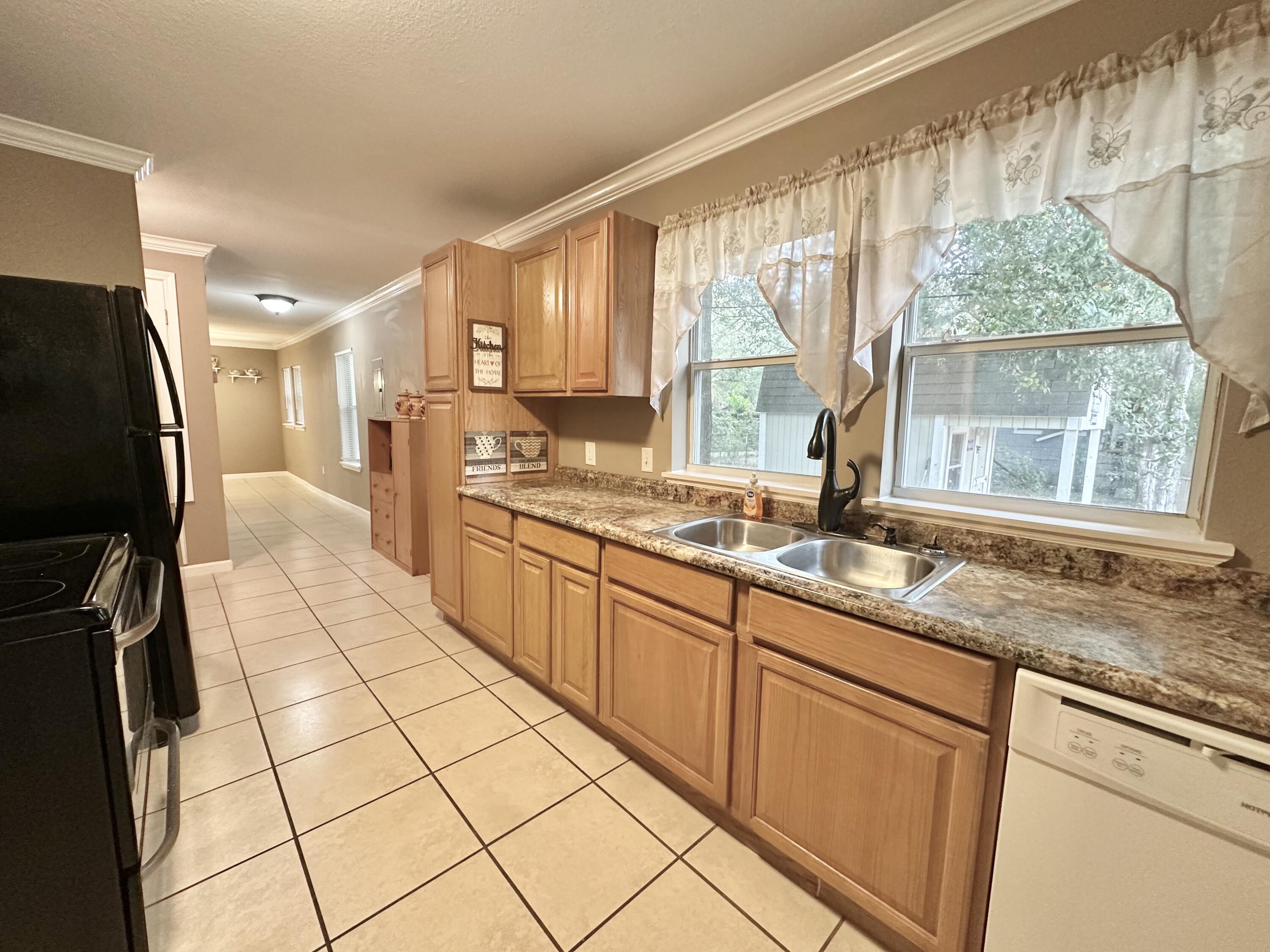 120 North Davis Lane DeFuniak Springs, FL 32433 - Photo 17 of 58 a large kitchen with kitchen island granite countertop a large window a sink stainless steel appliances and cabinets