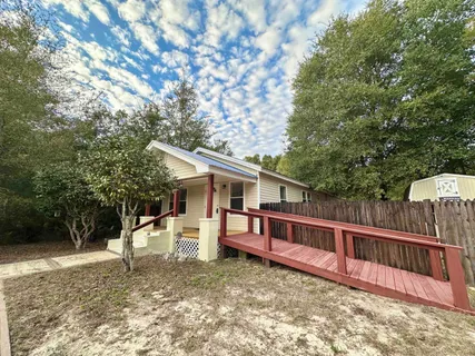 a view of a house with a backyard and a tree