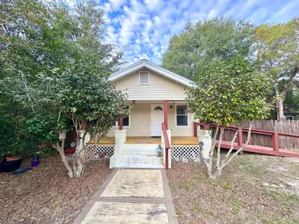 an aerial view of a house with a yard and greenery