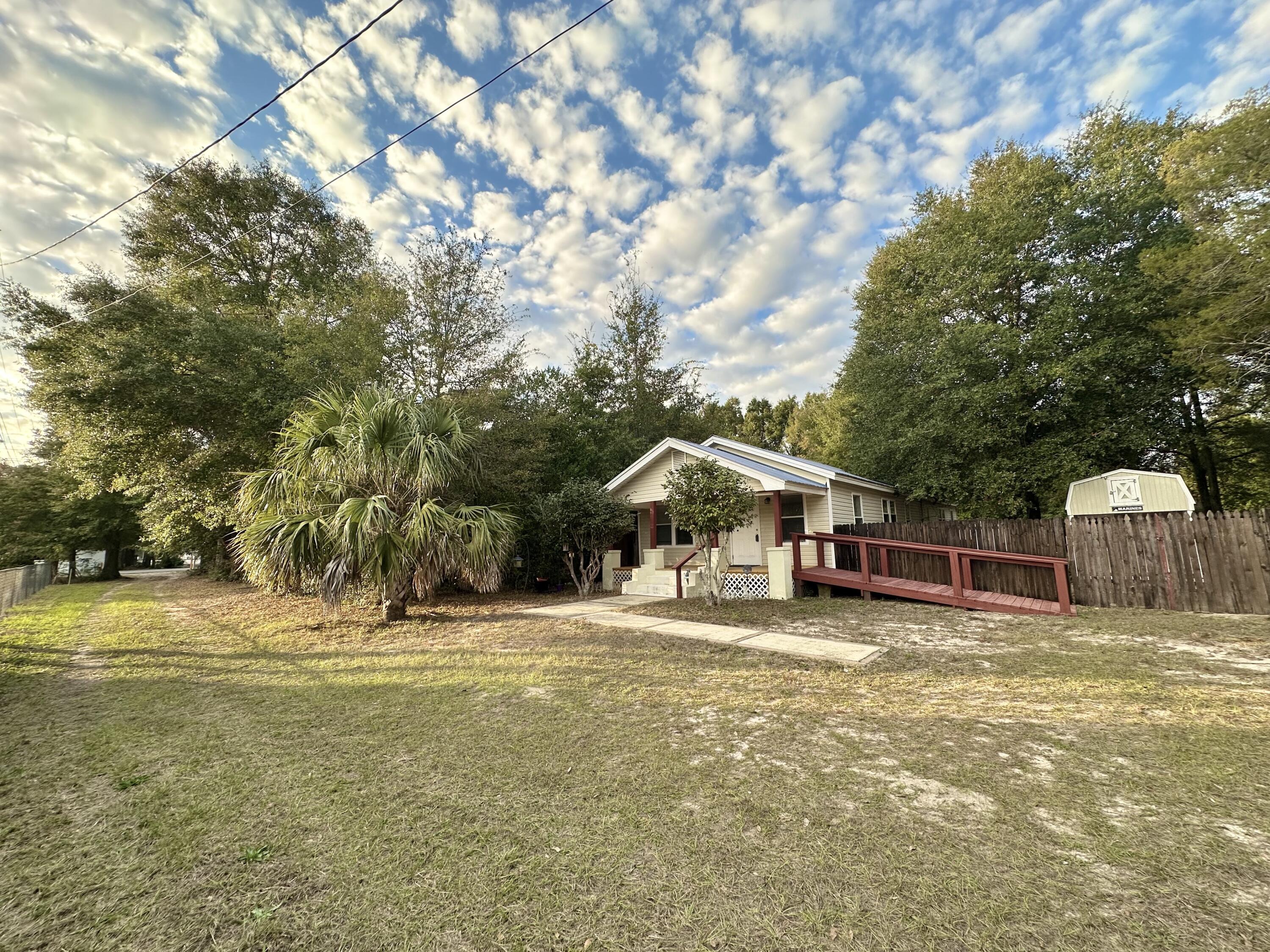 120 North Davis Lane DeFuniak Springs, FL 32433 - Photo 8 of 58 a view of a house with a yard and large trees