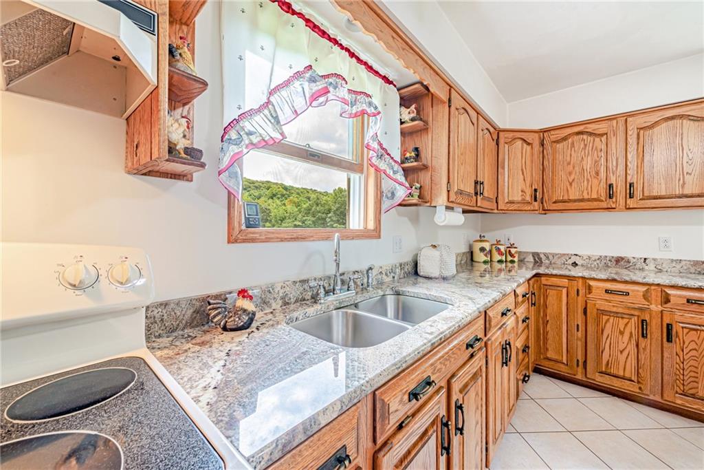 514 White Road Normalville, PA 15469 - Photo 11 of 32 a kitchen with stainless steel appliances granite countertop a sink stove and cabinets