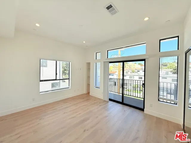 a view of an empty room with glass door and a window