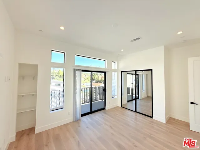 a view of an empty room with glass door and balcony