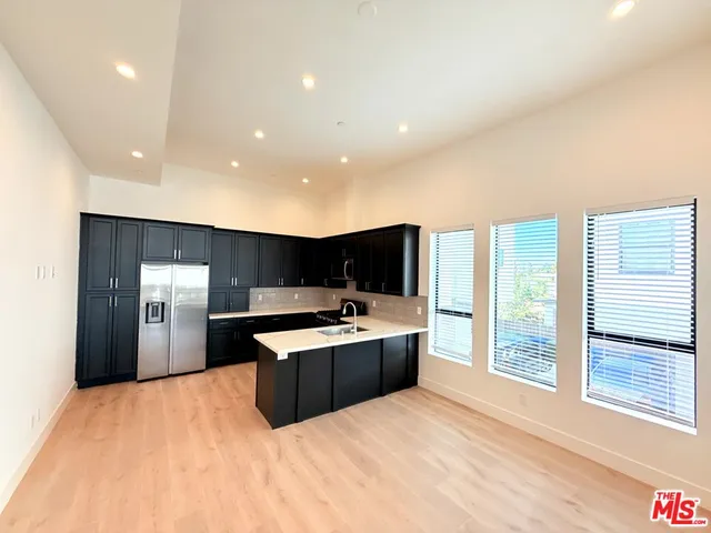a large white kitchen with a large window and stainless steel appliances